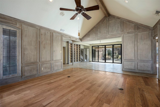 unfurnished living room with beamed ceiling, wood-type flooring, ceiling fan with notable chandelier, and high vaulted ceiling