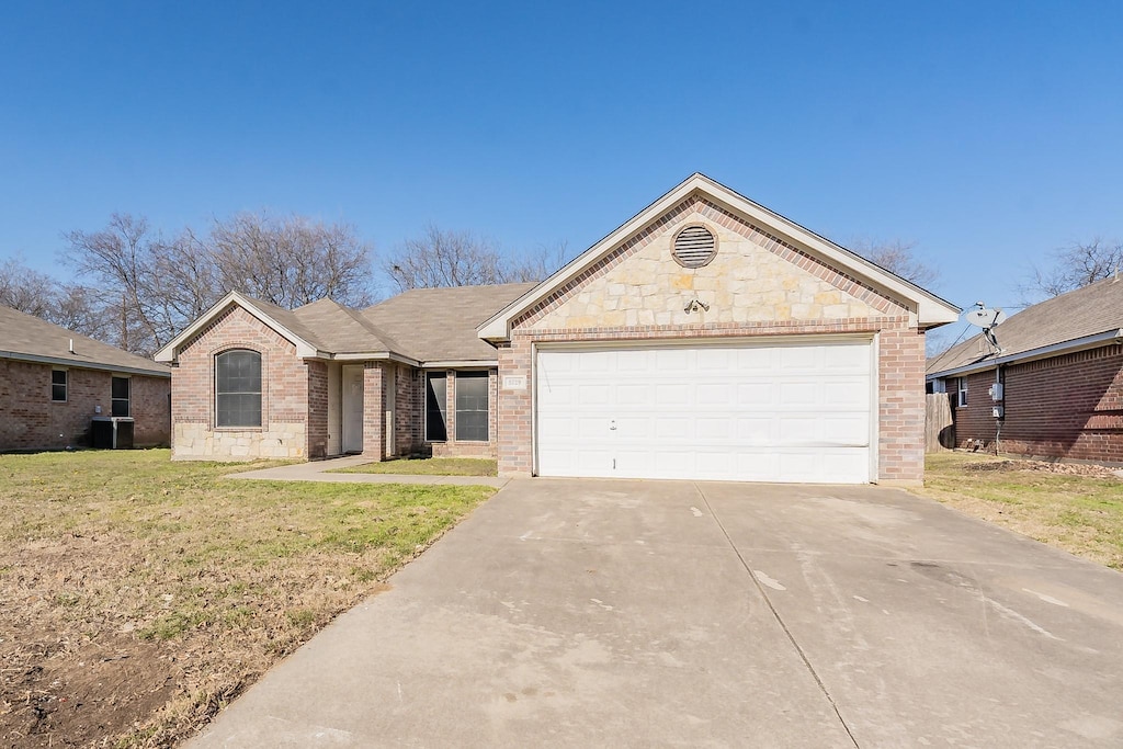 single story home featuring a garage, cooling unit, and a front lawn