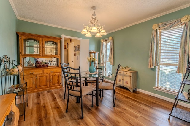 dining area featuring hardwood / wood-style flooring, crown molding, a textured ceiling, and an inviting chandelier