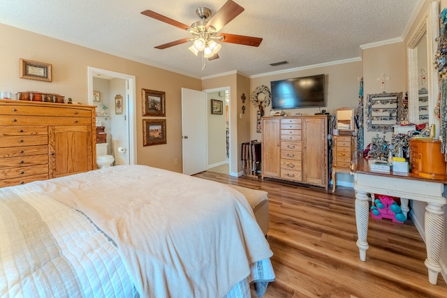 bedroom featuring ceiling fan, hardwood / wood-style floors, ensuite bathroom, ornamental molding, and a textured ceiling