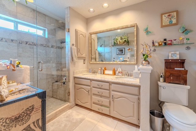 bathroom with vanity, a shower with shower door, tile patterned floors, and toilet