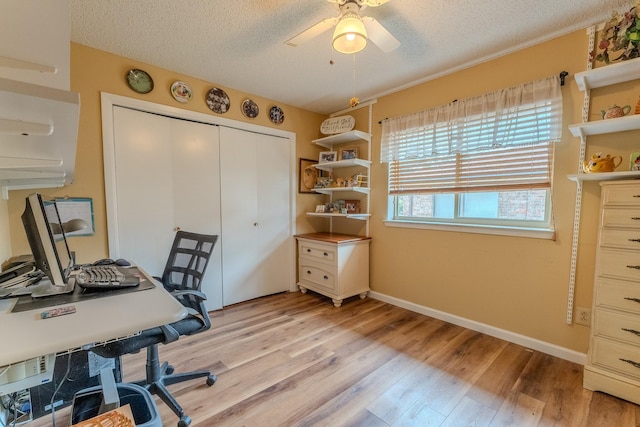 home office with ceiling fan, light hardwood / wood-style floors, and a textured ceiling