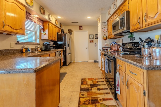 kitchen featuring sink, dark stone countertops, stainless steel appliances, a textured ceiling, and light tile patterned flooring