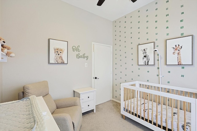 carpeted bedroom with a nursery area and ceiling fan