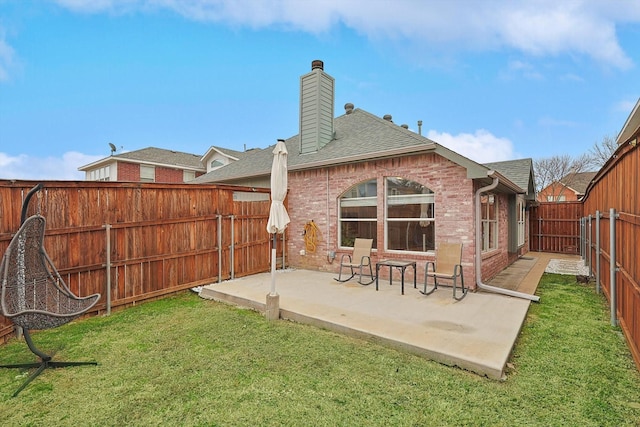 rear view of house featuring a lawn and a patio