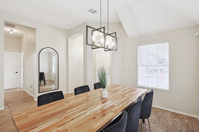 dining area featuring lofted ceiling and a chandelier