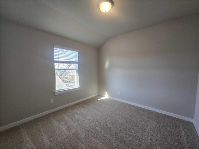 carpeted spare room with vaulted ceiling