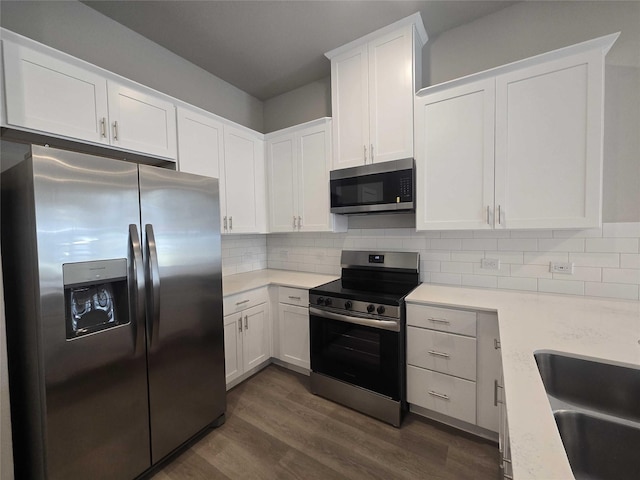 kitchen with appliances with stainless steel finishes, dark hardwood / wood-style flooring, sink, and white cabinets