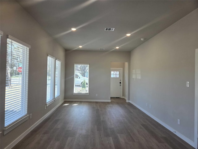 unfurnished room with a healthy amount of sunlight and dark hardwood / wood-style flooring