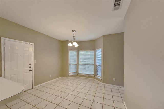 tiled empty room with a chandelier