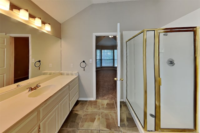 bathroom featuring vanity, vaulted ceiling, and a shower with door