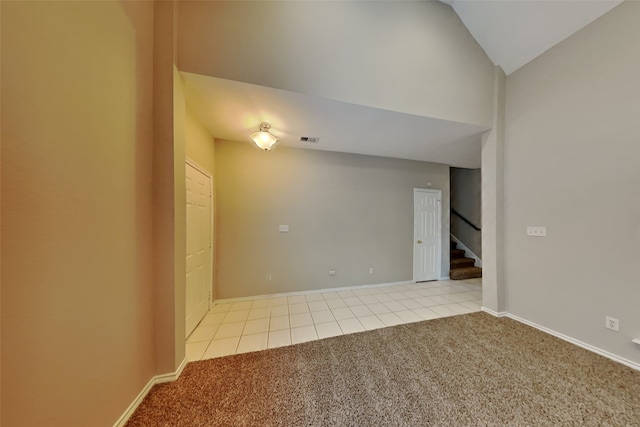 carpeted spare room with vaulted ceiling