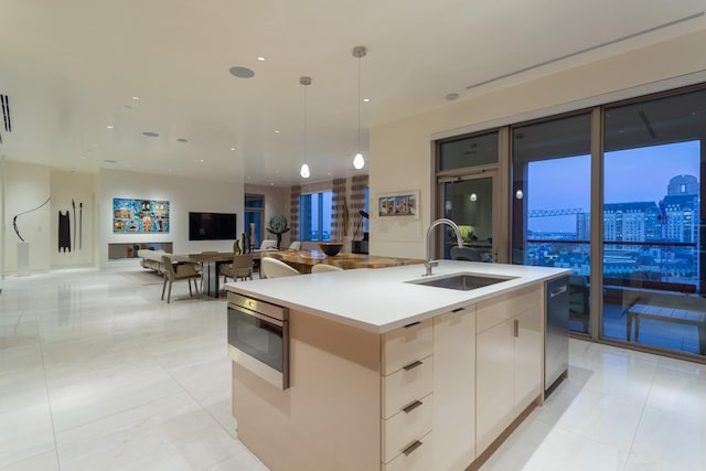 kitchen featuring pendant lighting, sink, a kitchen island with sink, white cabinets, and light tile patterned flooring