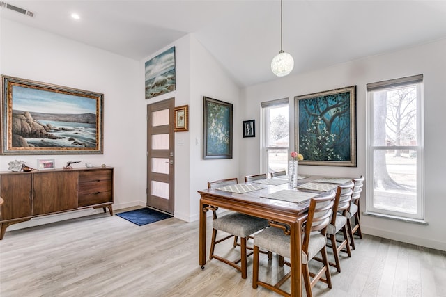 dining area featuring lofted ceiling, a wealth of natural light, and light hardwood / wood-style flooring