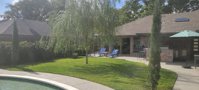 view of yard featuring area for grilling, exterior bar, and a patio