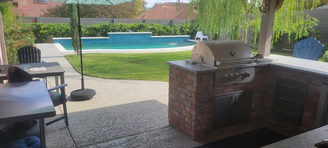 view of patio with an outdoor kitchen, a grill, and a fenced in pool