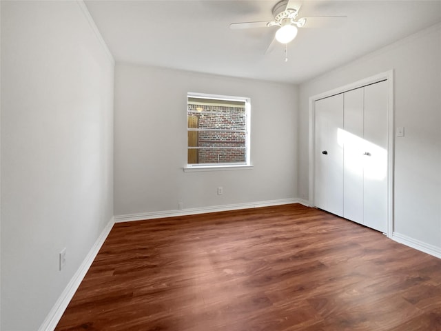 unfurnished bedroom with ornamental molding, dark hardwood / wood-style floors, ceiling fan, and a closet