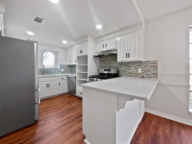 kitchen with stainless steel appliances, white cabinets, backsplash, and kitchen peninsula