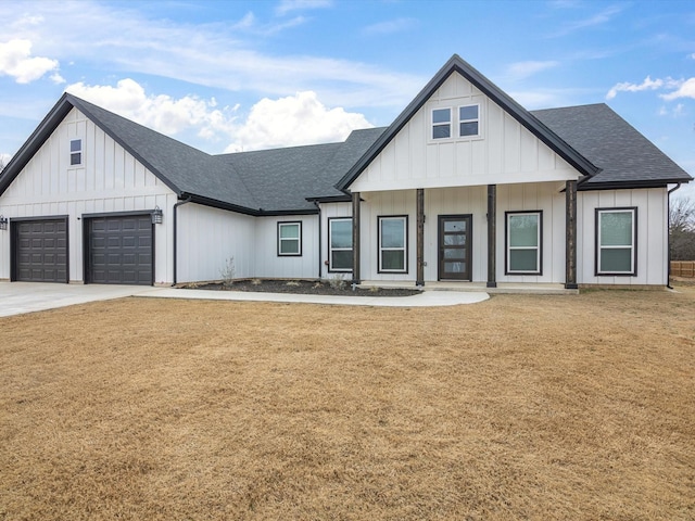 modern inspired farmhouse featuring a garage and a front yard