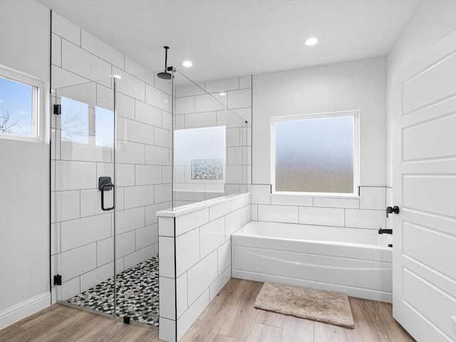 bathroom featuring plus walk in shower and hardwood / wood-style floors