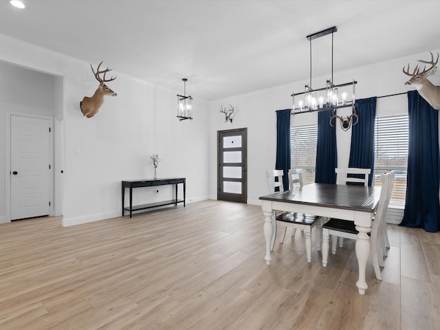 dining space featuring light hardwood / wood-style floors and a notable chandelier