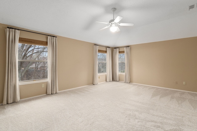 unfurnished room featuring ceiling fan, plenty of natural light, carpet flooring, and vaulted ceiling