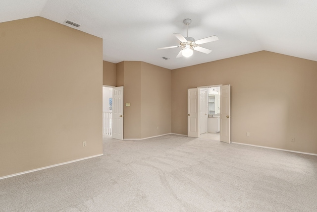 spare room with vaulted ceiling, light carpet, and ceiling fan