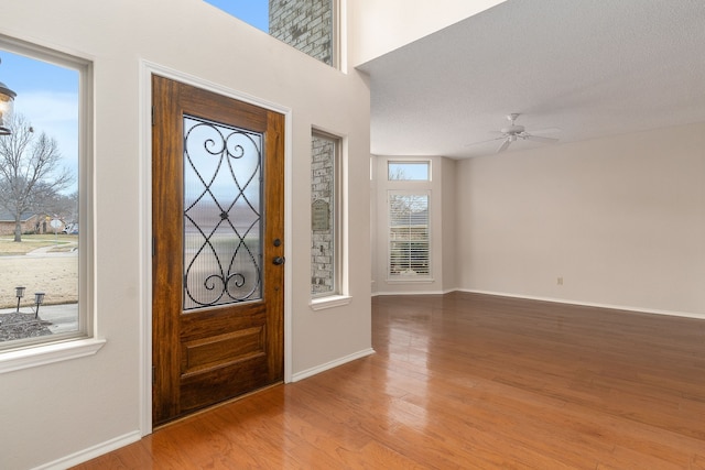 foyer entrance featuring hardwood / wood-style floors, a textured ceiling, and ceiling fan