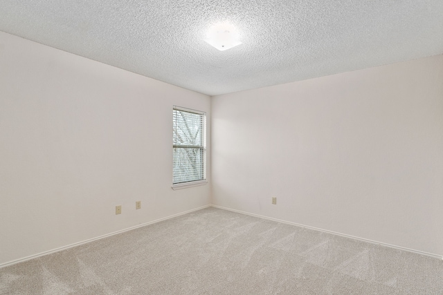 carpeted spare room featuring a textured ceiling