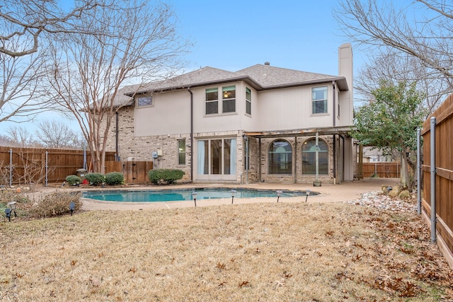 back of house featuring a fenced in pool and a patio area