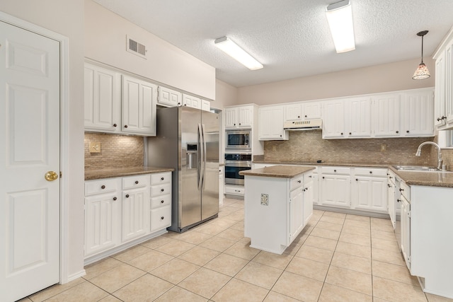 kitchen with sink, white cabinetry, a kitchen island, pendant lighting, and stainless steel appliances