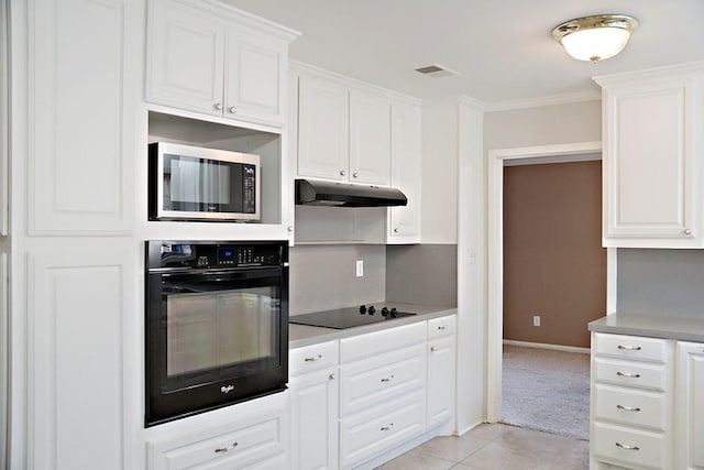 kitchen featuring white cabinetry, ornamental molding, light tile patterned flooring, and black appliances