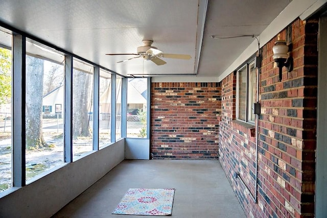 unfurnished sunroom featuring ceiling fan