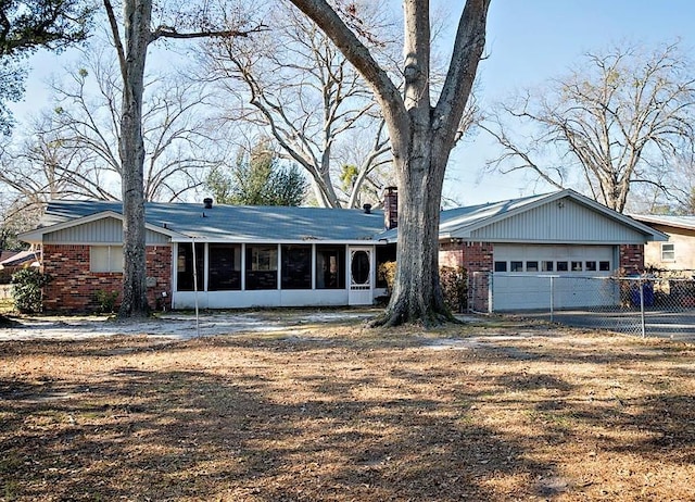 ranch-style home featuring a garage and a sunroom