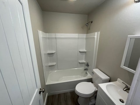 full bathroom with hardwood / wood-style flooring, vanity, toilet, and shower / bath combination