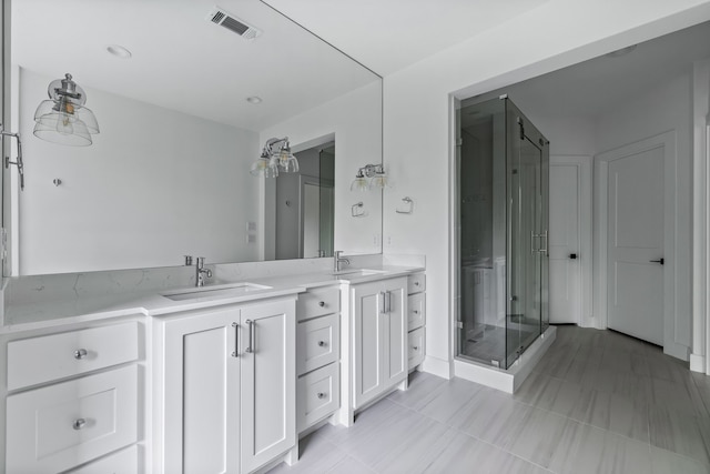 bathroom featuring vanity, an enclosed shower, and tile patterned floors