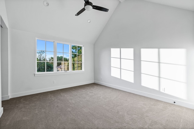 carpeted empty room with high vaulted ceiling and ceiling fan