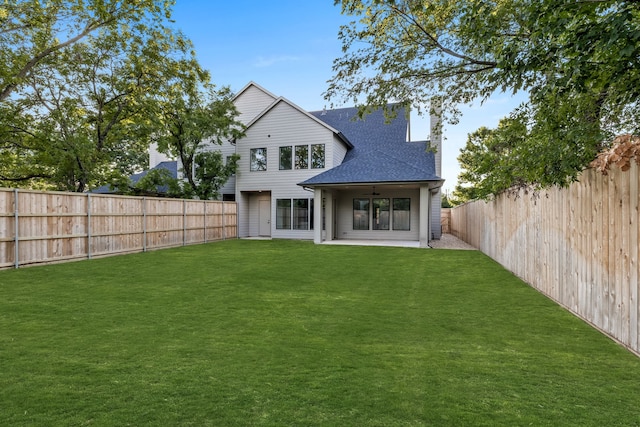 rear view of property with a patio, ceiling fan, and a lawn