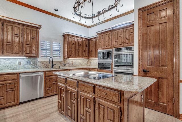 kitchen with ornamental molding, appliances with stainless steel finishes, brown cabinetry, and a sink