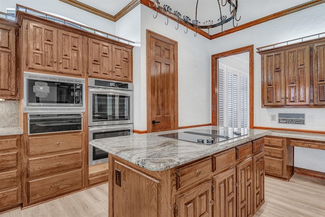 kitchen featuring crown molding, stainless steel appliances, a kitchen island, and light wood-style floors