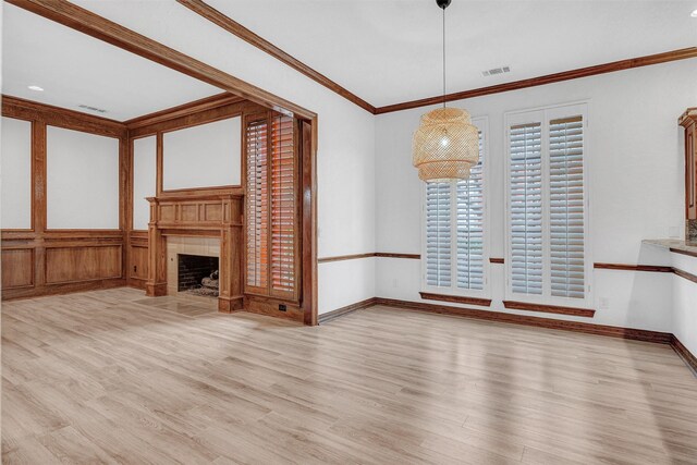 kitchen featuring hanging light fixtures, ornamental molding, stainless steel oven, and light wood-type flooring