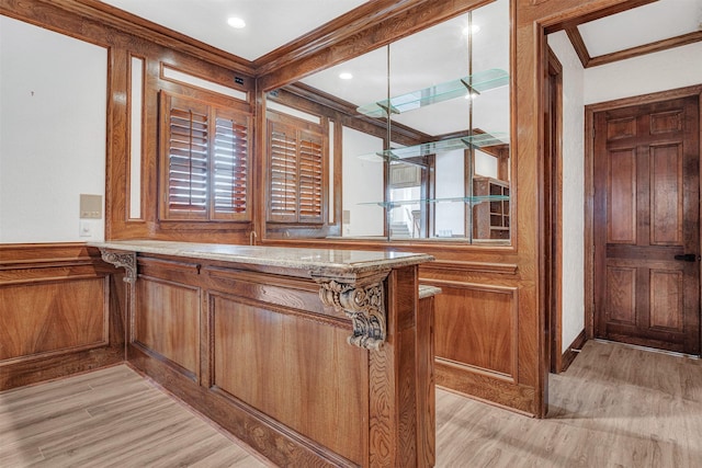 bar featuring crown molding and light hardwood / wood-style floors