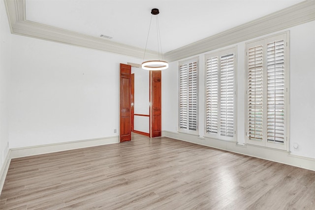 unfurnished dining area featuring ornamental molding, wood finished floors, visible vents, and baseboards