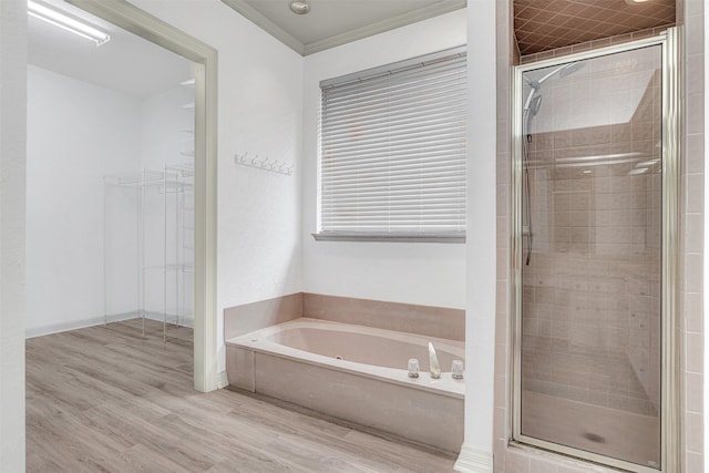 bathroom with a garden tub, a shower stall, and wood finished floors