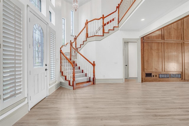 foyer featuring a notable chandelier, a high ceiling, and light wood-type flooring