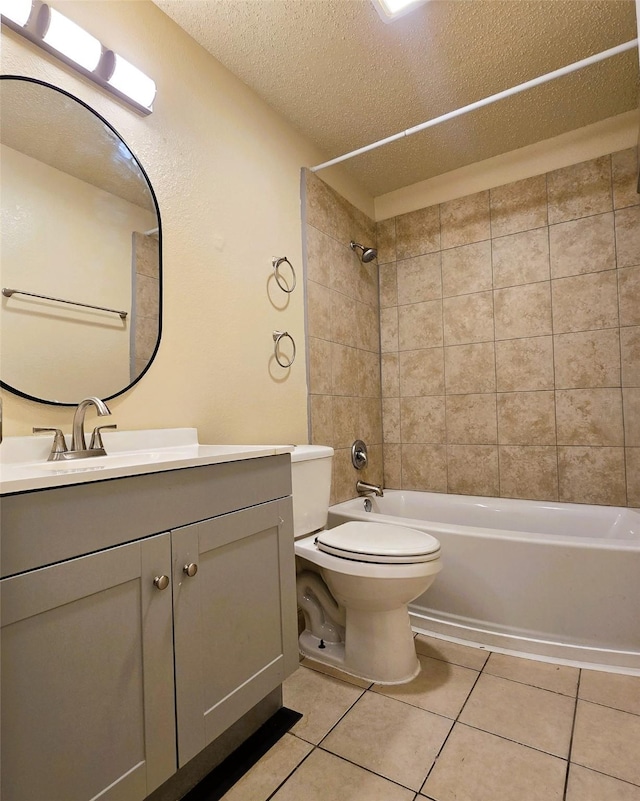 full bathroom with tiled shower / bath combo, vanity, toilet, tile patterned floors, and a textured ceiling