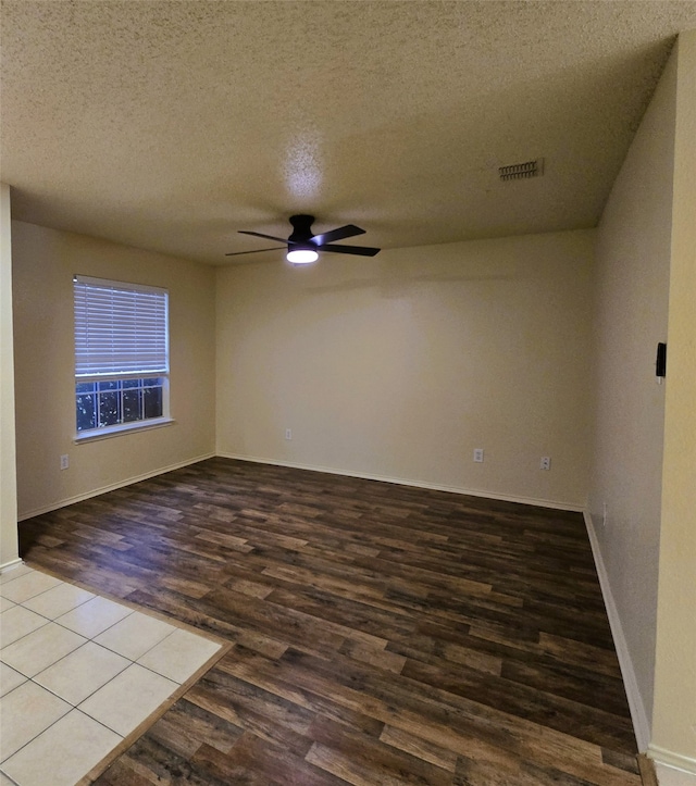 empty room featuring hardwood / wood-style flooring, a textured ceiling, and ceiling fan