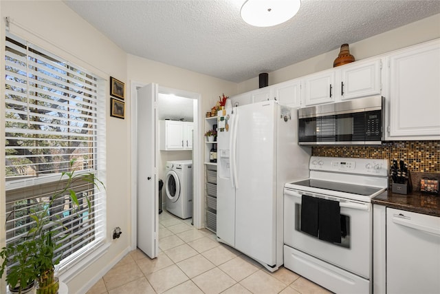 kitchen with white appliances, a sink, white cabinetry, and decorative light fixtures