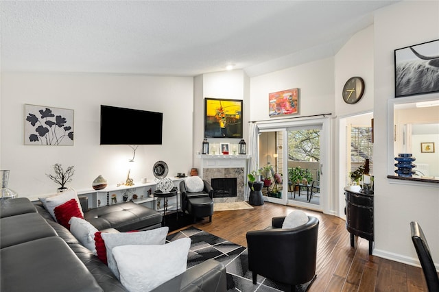 living area featuring a high end fireplace, baseboards, vaulted ceiling, wood finished floors, and a textured ceiling