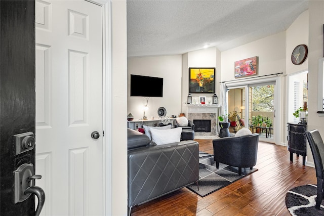 bedroom featuring ceiling fan, a textured ceiling, baseboards, and wood finished floors